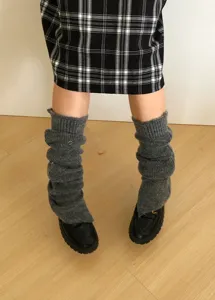 Detailopname van donkergrijze gebreide beenwarmers, comfortabele wintermode-accessoire.