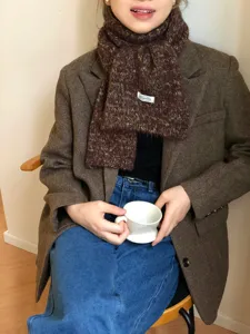 Dettaglio ravvicinato della comoda sciarpa invernale in misto lana melange con blazer in tweed.
