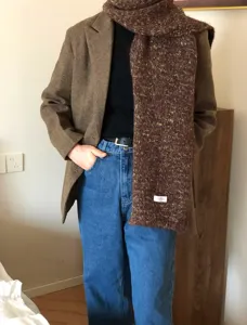Dettaglio sciarpa maculata in misto lana invernale, foulard in maglia accogliente stile vintage.