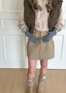 Vue détaillée de gants tactiles en tricot gris douillets associés à une tenue d'automne.