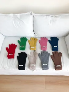 Primer plano detallado de guantes de invierno de lana cálida tejidos en sofá blanco.