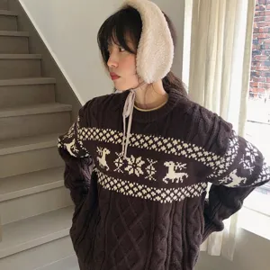 Close-up detail of the fluffy plush earmuffs and cozy knit sweater worn by the model.