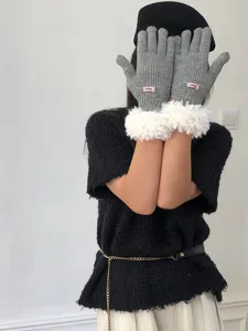 Women's grey knit gloves featuring fluffy white faux fur cuffs and a chic pink tag detail.