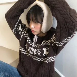 Fluffy winter earmuffs and cozy brown knit sweater detail, perfect for cold weather.