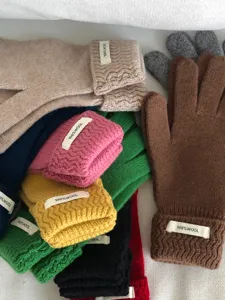 Detalle de guantes de punto de lana de invierno con textura suave y múltiples colores.