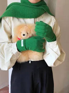 Primer plano detallado de cálidos guantes de punto de lana de invierno en verde brillante y suaves.