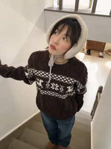 Cozy winter knit sweater paired with plush warm earmuffs for cold weather daily casual outdoor wear.