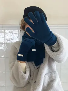 Primer plano de guantes de invierno cálidos de lana y bufanda lisa con etiqueta.