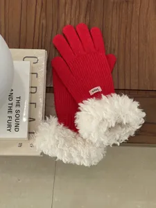 Detailed view of red winter knitted gloves with fluffy plush cuffs for cozy cold weather warmth.