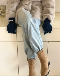 Guantes de invierno de punto en azul oscuro con textura de lana cálida, ideales para días fríos.