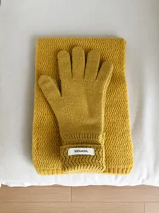 Vista detallada del conjunto de guantes y bufanda de invierno de lana con textura tejida.