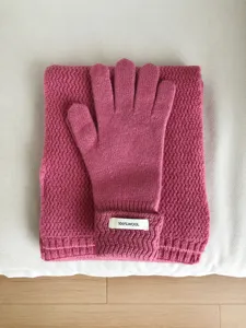 Vista detallada de los guantes de lana tejidos abrigados y bufanda a juego en color rosa.