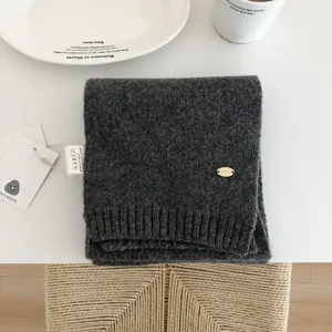 Vista detallada de bufanda de punto de lana gris oscuro, accesorio de invierno minimalista.