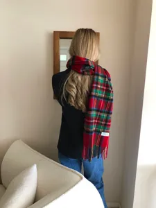 Vue détaillée d'une écharpe d'hiver en laine à carreaux rouges avec franges, stylée.