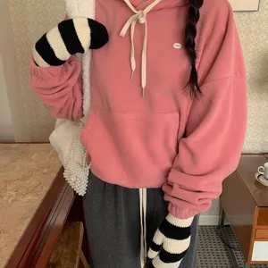 Mitaines tricotées rayées chauds d'hiver combinées avec un sweat à capuche rose.
