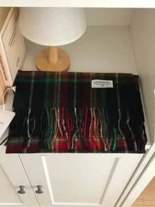 Détail d'écharpe d'hiver à carreaux classique, châle confortable en laine avec franges et étiquette.