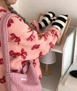 Vue détaillée de mittons rayés d'hiver douillettes, avec texture tricotée douce et veste polaire.