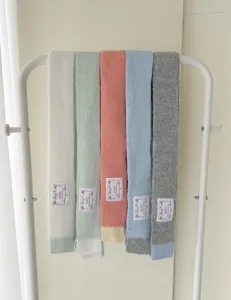 Vue détaillée de longues écharpes en tricot d'hiver avec des pointes de couleur et étiquette.