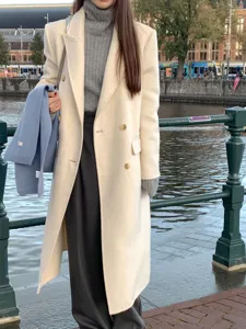 Detail shot of winter wool coat and blue scarf in urban street scene, stylish warm fashion wear.
