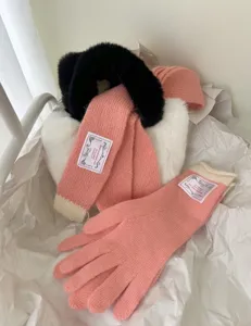 Vue détaillée de l'écharpe et des gants en tricot rose d'hiver avec des détails en fausse fourrure.