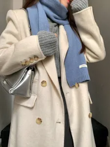 Detailed view of the cozy haze blue solid wool scarf styled with elegant winter coat.
