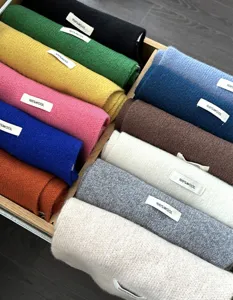 Solid color 100% wool scarf detail showing rich color options neatly rolled in wooden box.
