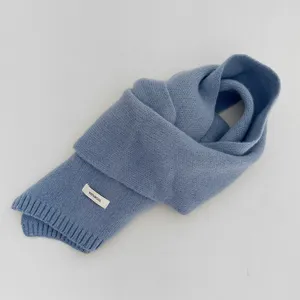 Detailed view of the fog blue knitted wool scarf close up showing soft fabric texture and label.
