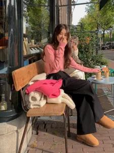 Cozy winter lifestyle detail shot featuring a woman in a casual outfit at a charming street cafe.
