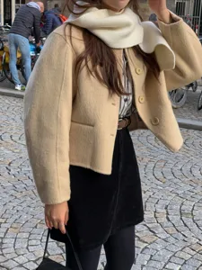 Winter women solid color wool coat and knitted scarf outfit, elegant daily street fashion.