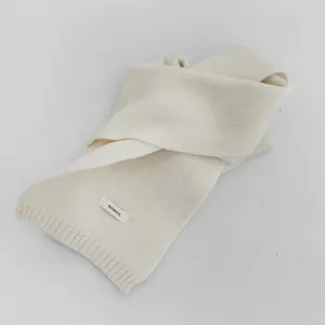 Close-up detail of a soft solid color winter wool knit scarf with fine textured weave.