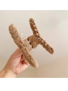 Cozy brown plush hair claw clip for women, large winter hair accessory for styling buns.
