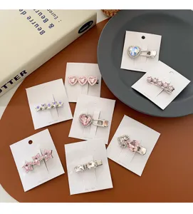 Gros plan de pinces à cheveux scintillantes en strass avec motifs cœur et étoile sur cartes.
