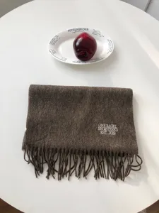 Brauner Wollschal mit Fransen und feiner Stickerei, ideal fuer den Winter und Alltag.