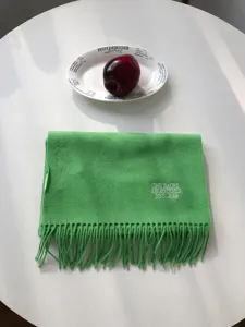 Grüner Wollschal mit besticktem Text und Fransen-Detail, gemütlicher Winter-Halswärmer.