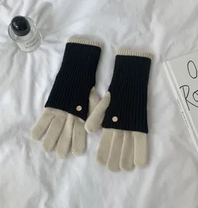 Detailed view of contrast color knit gloves featuring black and beige design with elegant buttons.