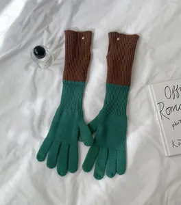 Long color-block knit gloves feature contrasting brown cuffs and green fingers, ideal for autumn style.