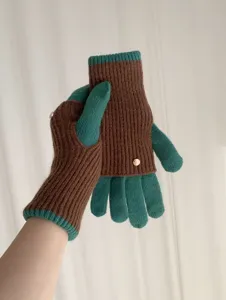 Close-up of contrast color knit gloves featuring chic metal buttons and cozy warm design.