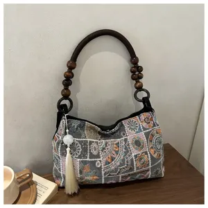 Borsa a mano ricamata in stile etnico con manico di perle di legno e dettaglio nappa.