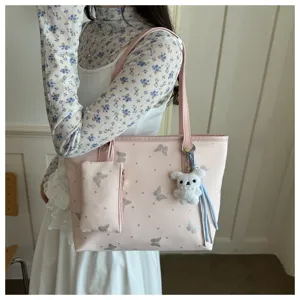 Dettaglio borsa shopper rosa, motivo farfalla glitterato, borsa a spalla casual.