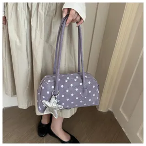 Detailed shot of purple polka dot bowling shoulder bag with star charm and double straps.