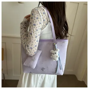 Vista dettagliata della borsa a spalla viola chiaro con ciondolo coniglietto e farfalle.