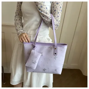 Dettaglio della borsa tote viola chiaro con motivo a farfalla glitterata argentata e pochette.
