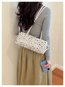 Vista dettagliata della borsa a baguette da donna con stelle nere e design ricamato.