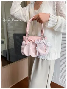 Pink polka dot pleated shoulder bag for women, stylish handbag with bow and pearl decor.