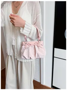 Dettaglio borsa a spalla rosa a pois, design con fiocco carino, elegante borsa giornaliera.
