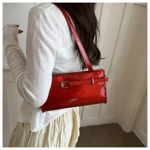Red patent leather shoulder bag with chic metal buckle detail, stylish underarm design for women.