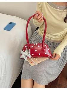 Red glossy polka dot shell shoulder bag detail, stylish underarm bag with silver star charm.