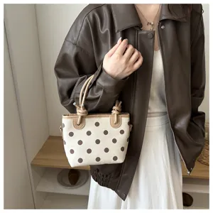 Gros plan détaillé du sac seau élégant en toile à pois avec poignées nouées et bordure.