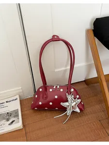 Detailed view of the red polka dot leather shoulder bag with stylish silver star charm.