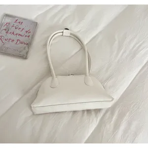 Detailed view of the minimalist white shoulder underarm shell bag, elegant everyday style.